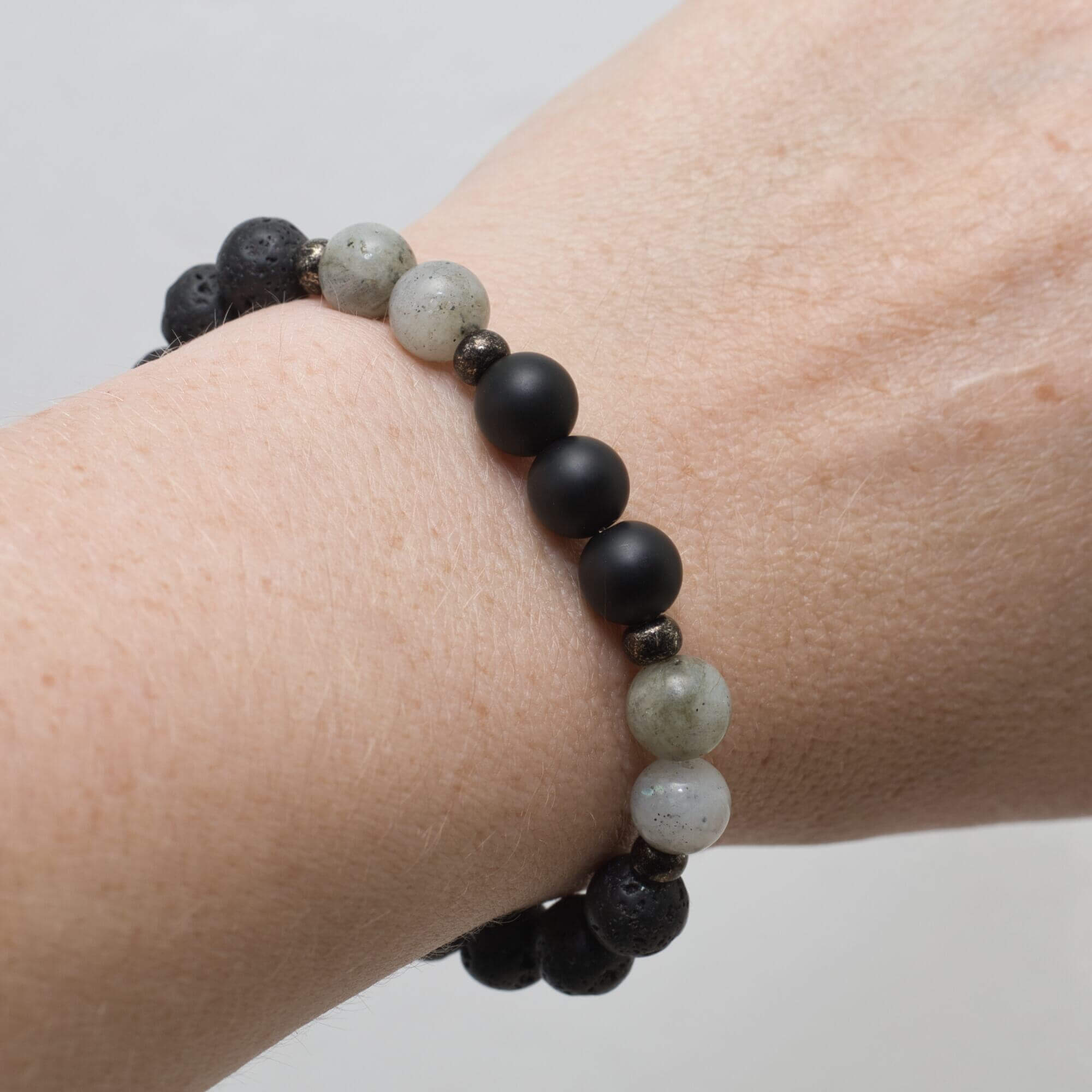 Gemstone bracelet, a harmonious blend of black Lava, matte Onyx, and Labradorite stones, combined with small glass beads.