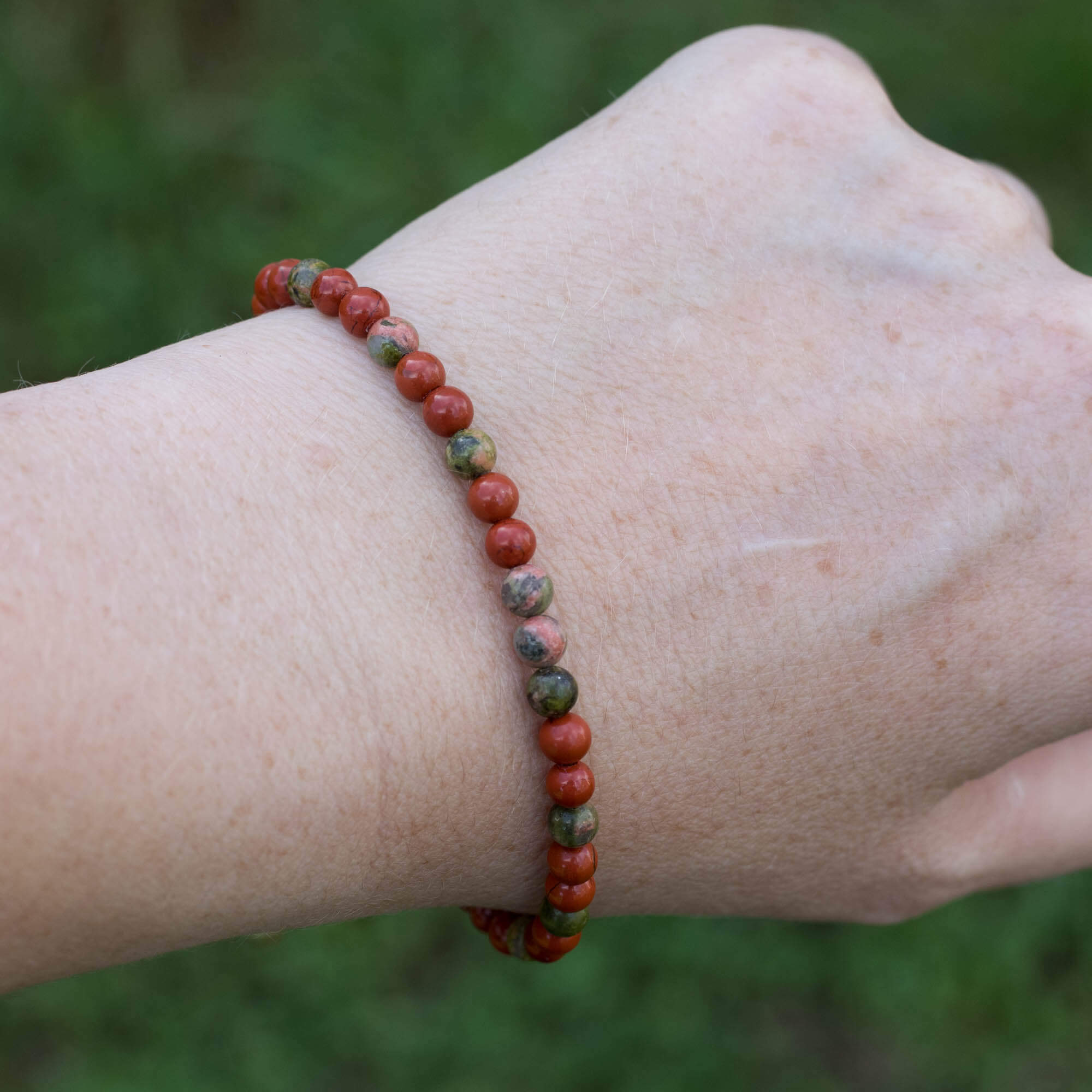 Gemstone bracelet made with Unakite and Red Jasper. Beads are strung on waxed polyester thread adjustable with a sliding knot.