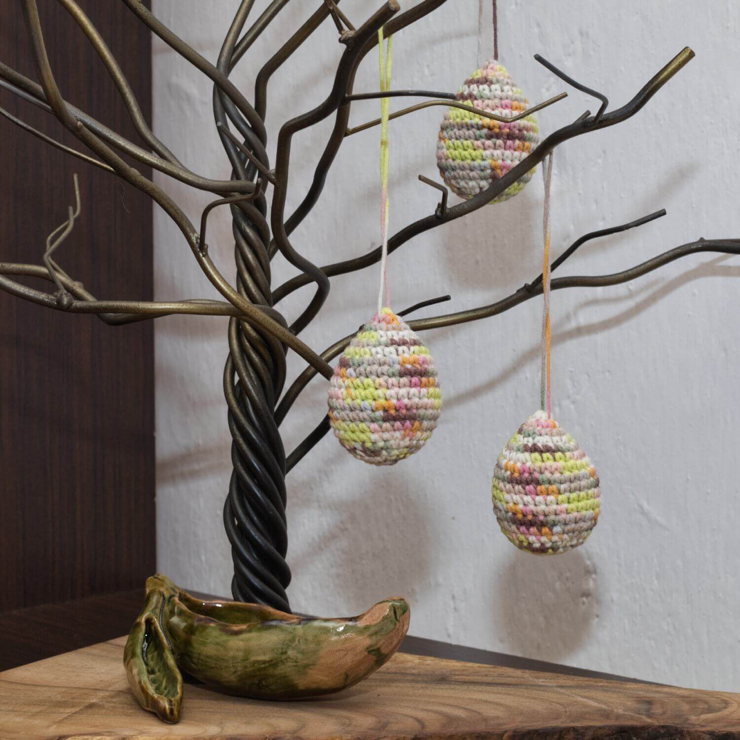 Colorful hanging crochet Easter eggs made from yarn and filled with hollow fiber stuffing.