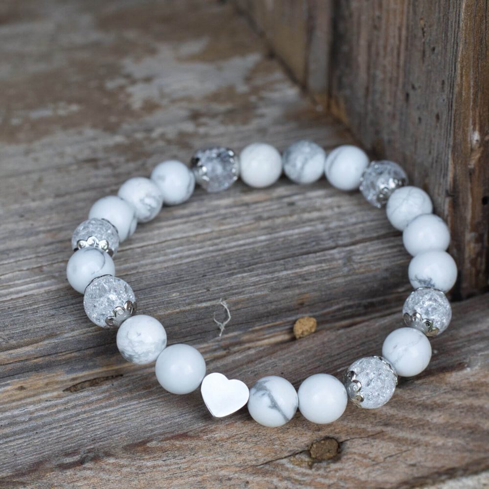 Elegant white bracelet for women. It features beautiful Howlite and Crystal Quartz beads, complemented by stainless steel accents and a heart-shaped bead.