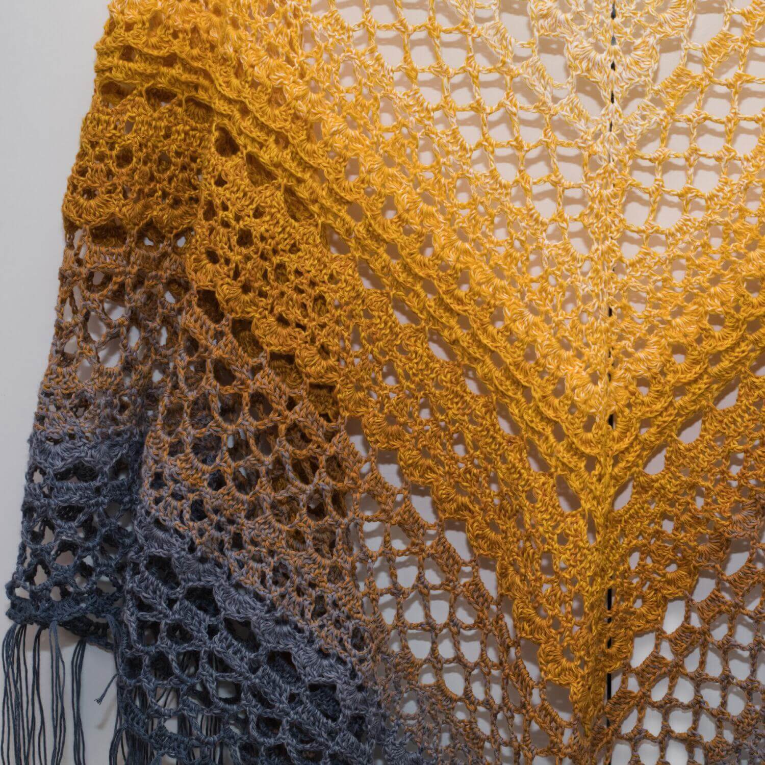 Handgemachtes gehäkeltes Dreieckstuch in Weiß, Senfgelb und Grau mit Fransen – elegantes Accessoire für jeden Tag.