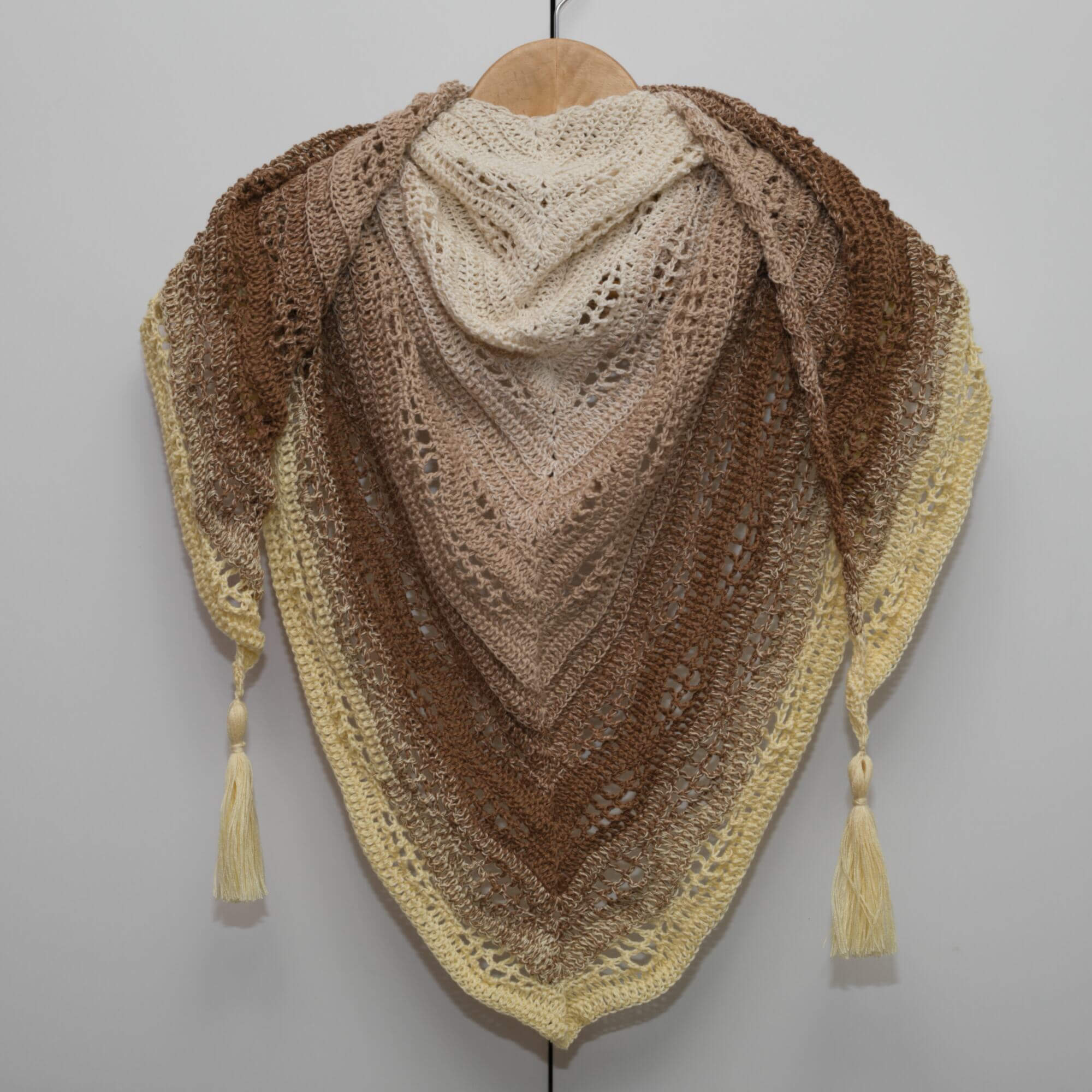 Handmade triangle crochet shawl for everyday use. The shawl is made from ombre yarn which smoothly goes from beige, brown to pastel yellow color.