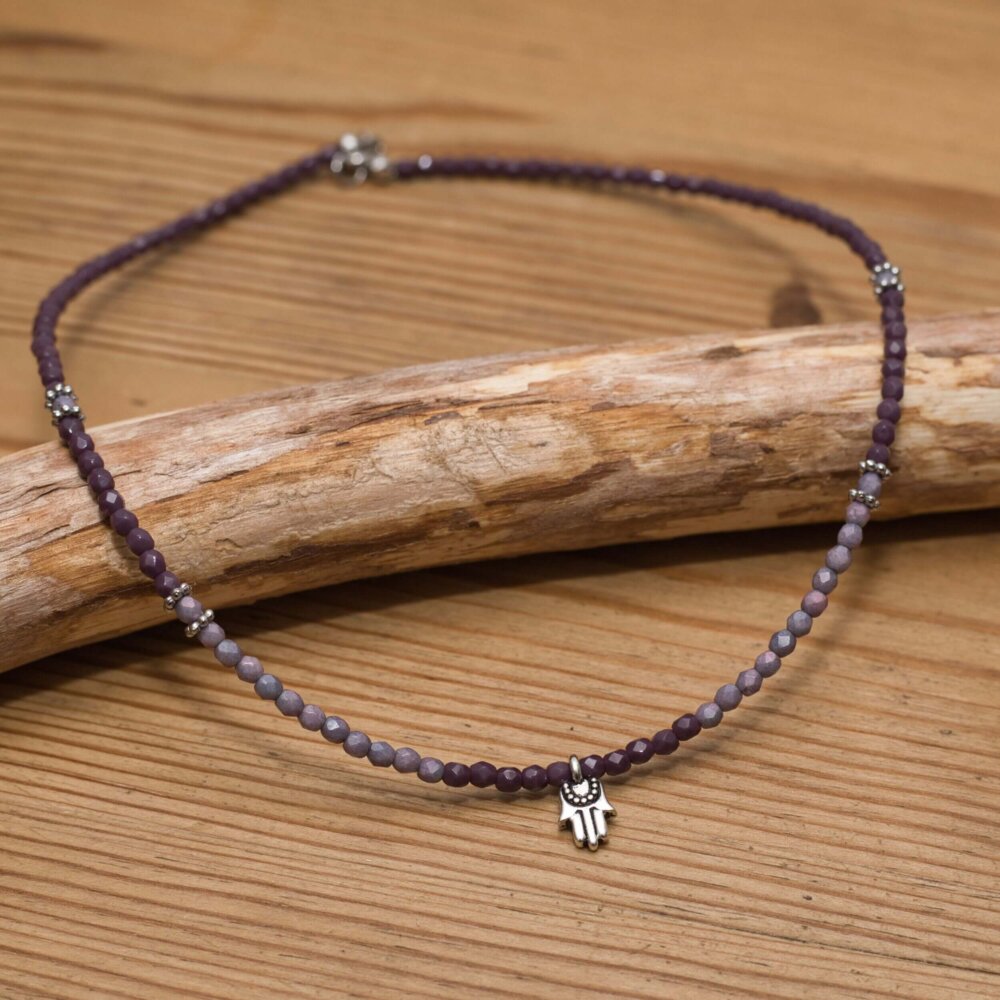 Handgefertigte Halskette mit violetten Glasperlen und Hamsa-Symbol für Schutz und Glück